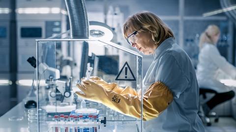 Un biologiste travaille sur des échantillons dans une boîte à gants d'isolation