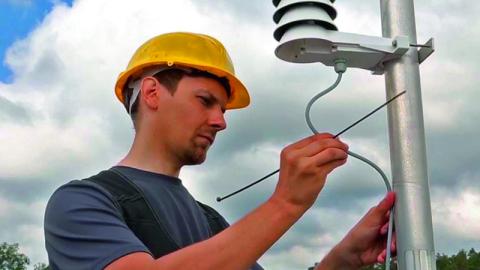 Engineer installing outdoor HVAC sensors