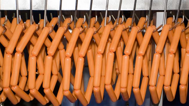Sausages hang on the conveyor
