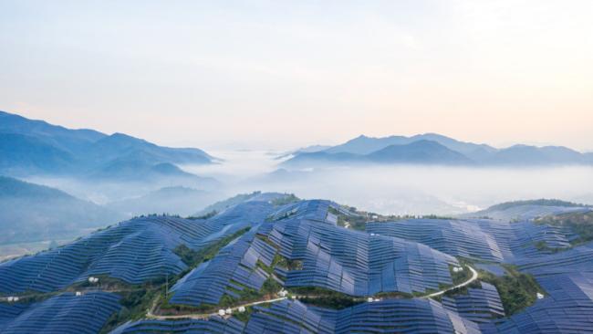 Elevated view of a solar farm on a mountain top in the morning sun 