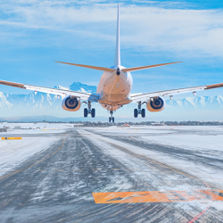 A view of a snowy runway and an airplane landing